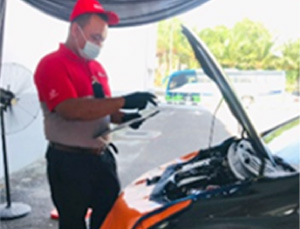 A Tweckbot staff inspects one of Perodua’s vehicles